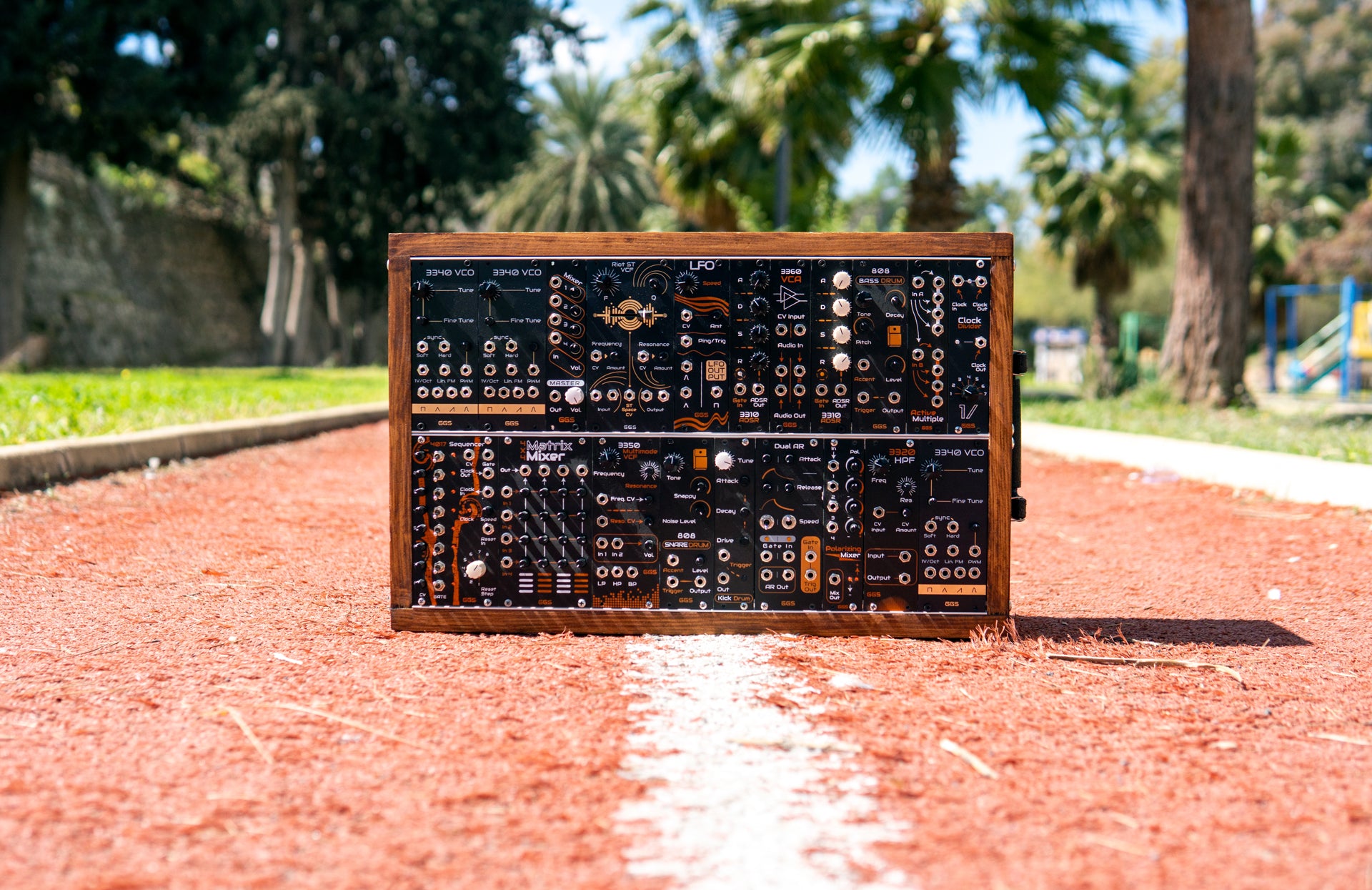 Photo of a GGS eurorack system in open air. Photo from the front taken in a park. Modules in the wooden rack are visible.