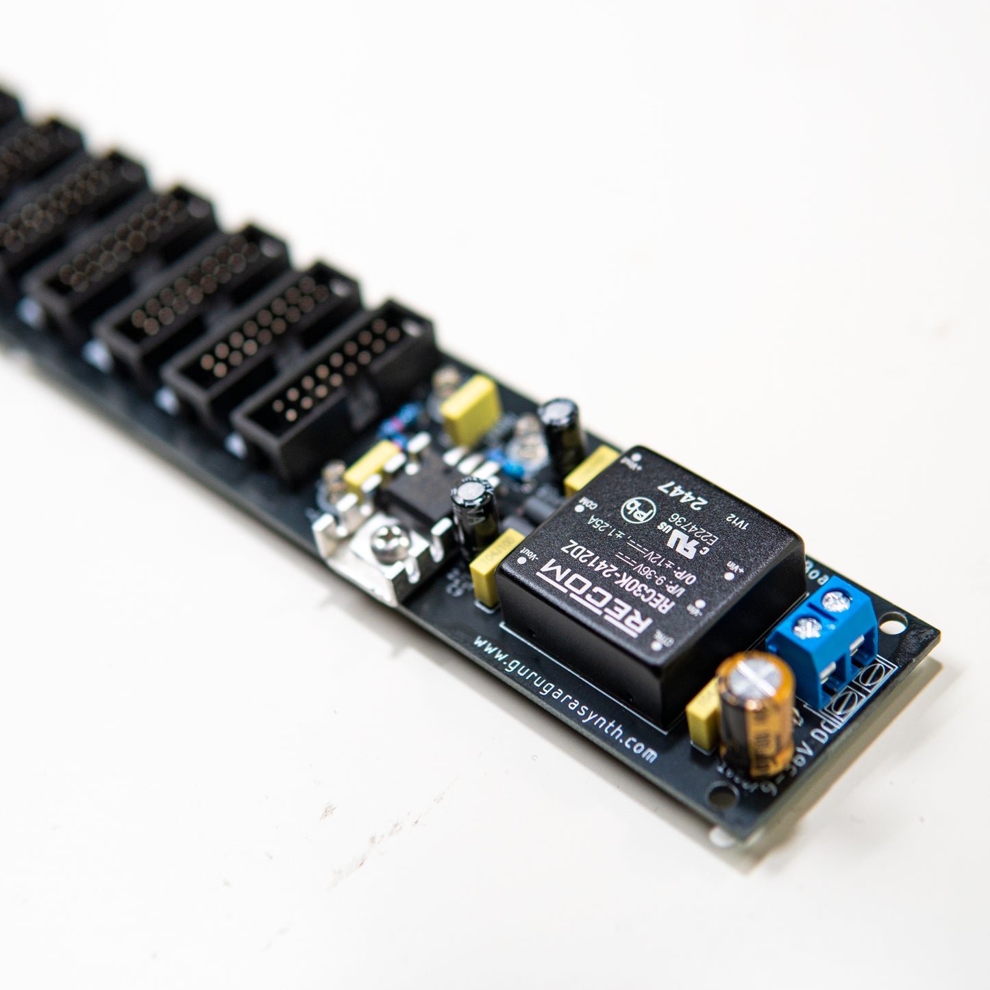 Eurorack power supply and bus board, power distribution. Synth PSU. +12V, -12V and +5V voltage regulator. Close up view. Components such as Recom power brick is visible.