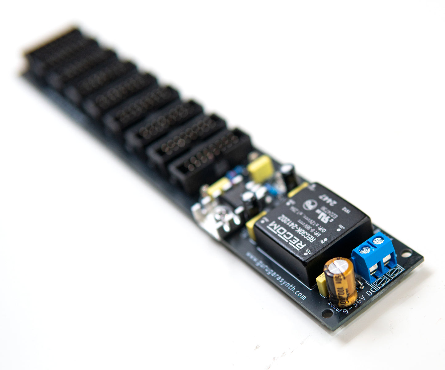 Eurorack power supply and bus board, power distribution. Synth PSU. +12V, -12V and +5V voltage regulator. Photo with an angle. DC input terminal visible.