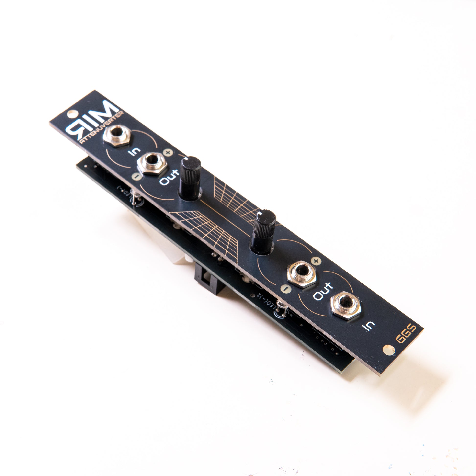 RIM - Eurorack dual attenuverter module. Angled photo with white background. Black panel with white and gold design. Potentiometers and jack sockets visible. 