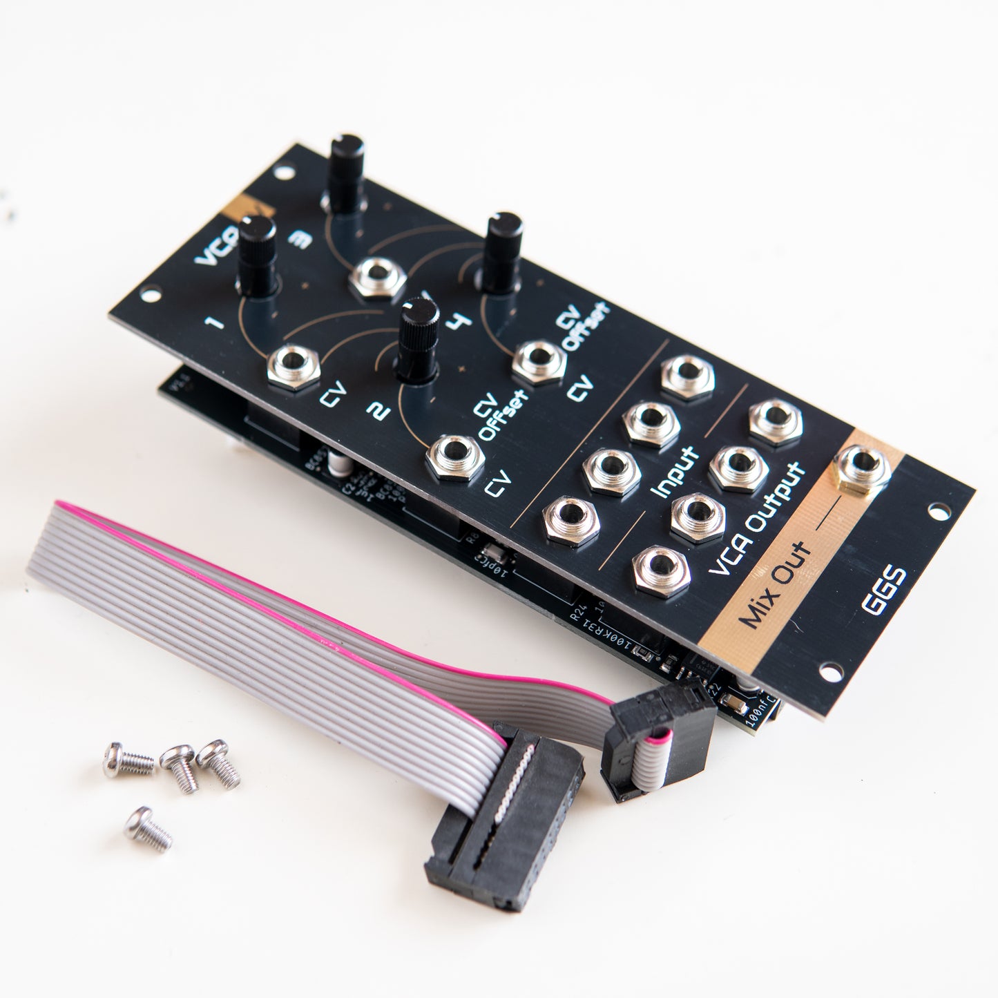 Quad VCA module for eurorack modular synth called VCA IV. Angled photo with white background, next to eurorack power cable and mounting screws. Gold plated Front panel PCB art is visible along with jack socket and potentiometer. GGS logo at the bottom. 